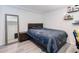 Cozy bedroom with comfortable bed, wood-look flooring, and a full-length mirror at 14120 E Warren Pl, Aurora, CO 80014