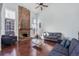 Spacious living room with a large brick fireplace, hardwood floors, and plenty of natural light from the oversized windows at 14120 E Warren Pl, Aurora, CO 80014