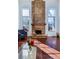 Sun-filled living room showcasing a brick fireplace, wood floors, and large windows at 14120 E Warren Pl, Aurora, CO 80014