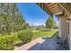 Back patio with pavers, an awning, green bushes, and lawn at 6114 Salvia Ln, Arvada, CO 80403