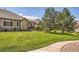 Expansive backyard features lush green lawn, mature trees, and a well-maintained landscape at 6114 Salvia Ln, Arvada, CO 80403