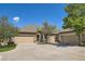 Charming home featuring a three-car garage, tan exterior, brick accents and mature landscaping at 6114 Salvia Ln, Arvada, CO 80403