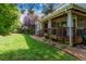 Backyard area with a covered porch, green lawn, and mature trees create a private retreat at 11930 E Lake Cir, Greenwood Village, CO 80111