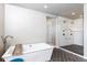 Bathroom featuring a modern tub, a spacious glass shower with multiple showerheads, and sleek tile at 11930 E Lake Cir, Greenwood Village, CO 80111