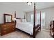 Comfortable bedroom featuring a four-poster bed, dresser, and a window with shutter blinds at 11930 E Lake Cir, Greenwood Village, CO 80111