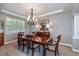 Formal dining room with a large window, tray ceiling, classic chandelier, and ample seating at 11930 E Lake Cir, Greenwood Village, CO 80111