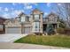 Charming two-story home featuring a manicured lawn, a three car garage, and detailed brickwork at 11930 E Lake Cir, Greenwood Village, CO 80111