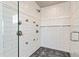Close-up of a luxurious glass shower with multiple showerheads and controls set against white subway tile at 11930 E Lake Cir, Greenwood Village, CO 80111