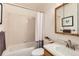 Bright bathroom featuring a tub, shower, vanity with sink, mirror and white tile at 1773 S Union Blvd, Lakewood, CO 80228