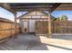 A spacious backyard patio featuring a wooden pergola, fenced yard, and access to a detached garage, offering privacy and shade at 1556 Osceola St, Denver, CO 80204