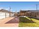 Fenced backyard features a pergola over a concrete patio, a grass lawn, and planter beds at 1556 Osceola St, Denver, CO 80204