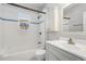 A tidy bathroom with tiled walls, a white vanity, and a shower/tub combo at 1556 Osceola St, Denver, CO 80204