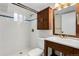 Updated bathroom features tiled walk-in shower, modern vanity, and wooden medicine cabinet at 1556 Osceola St, Denver, CO 80204