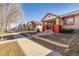 A charming home exterior showing the sidewalk, front yard with mature tree, and neighboring homes creating a welcoming curb appeal at 1556 Osceola St, Denver, CO 80204