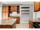 Spacious kitchen featuring open shelving, dark wood cabinets, granite counters, and stainless appliances at 1556 Osceola St, Denver, CO 80204