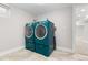 Laundry room features a tile floor and modern, matching blue washer and dryer at 1556 Osceola St, Denver, CO 80204