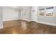 Bright living room showcasing hardwood floors, large windows, and a white front door at 1556 Osceola St, Denver, CO 80204