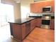 Kitchen featuring stainless steel appliances, a kitchen island, black countertops and light wood cabinets at 5401 S Park Terrace Ave # 204C, Greenwood Village, CO 80111