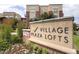 Village Plaza Lofts building signage with manicured landscaping, tall grasses, and the community building in the background at 5401 S Park Terrace Ave # 204C, Greenwood Village, CO 80111