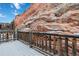 Backyard deck with log railing overlooking rock formations in the landscape at 10576 Roxborough Dr, Littleton, CO 80125