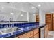 Basement bar area with blue tile, wood cabinetry, and stainless-steel sink at 10576 Roxborough Dr, Littleton, CO 80125