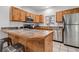 Bright kitchen with stainless steel appliances, wood cabinets, and tile countertops at 10576 Roxborough Dr, Littleton, CO 80125