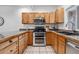 Functional kitchen featuring solid countertops, tiled floors and modern stainless steel appliances at 10576 Roxborough Dr, Littleton, CO 80125