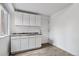 A bright kitchenette with white cabinetry, a granite countertop, and laminate floors at 10576 Roxborough Dr, Littleton, CO 80125