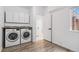 A functional laundry room featuring white cabinets, a new washer and dryer set, and tile floors at 10576 Roxborough Dr, Littleton, CO 80125