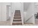 Bright, carpeted staircase with white banister provides access to upper levels at 10576 Roxborough Dr, Littleton, CO 80125