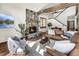 Cozy living room featuring a stone fireplace, wood beams, comfortable seating, and a view of the staircase at 120 Windwood Cir, Breckenridge, CO 80424