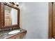 Stylish powder room with a granite countertop vanity and a decorative framed mirror at 120 Windwood Cir, Breckenridge, CO 80424