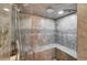 Luxurious tiled shower stall featuring pebble accents and built-in bench at 120 Windwood Cir, Breckenridge, CO 80424