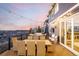 Inviting back deck features an outdoor dining set and comfortable lounge furniture, perfect for enjoying the scenic sunset views at 1825 Wingfeather Ln, Castle Rock, CO 80108
