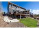 Beautiful backyard with a large deck, grassy area, and concrete walkway at 1825 Wingfeather Ln, Castle Rock, CO 80108