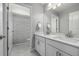 A bathroom with double vanity, white cabinets, marble floors, and a shower behind a door at 1825 Wingfeather Ln, Castle Rock, CO 80108