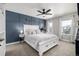 Stylish bedroom with a blue accent wall, white furniture, and plenty of natural light at 1825 Wingfeather Ln, Castle Rock, CO 80108