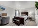 A primary bedroom featuring a large bed, bench, nightstand, and an interesting TV on the wall at 1825 Wingfeather Ln, Castle Rock, CO 80108