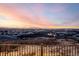 A stunning distant view of the city and mountains during sunset. Nice iron railing in the foreground at 1825 Wingfeather Ln, Castle Rock, CO 80108