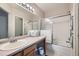 Clean bathroom with a shower-tub combo, framed glass doors, and a single sink vanity at 4349 S Genoa Ct, Centennial, CO 80015