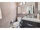 Modern powder room featuring updated fixtures, stylish wallpaper, and a sleek vessel sink at 4349 S Genoa Ct, Centennial, CO 80015