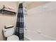 Bathroom with tiled shower-tub combo, toilet, and decorative towels and storage shelves at 4349 S Genoa Ct, Centennial, CO 80015