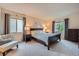 Comfortable bedroom featuring two windows with draperies, neutral carpet, and stylish furnishings at 4349 S Genoa Ct, Centennial, CO 80015