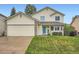 Charming two-story home with a well-manicured lawn, light yellow siding, and an attached two car garage at 4349 S Genoa Ct, Centennial, CO 80015