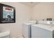 Bright laundry area featuring a washer, dryer, and a framed Jaws movie poster at 4349 S Genoa Ct, Centennial, CO 80015