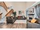Bright living room featuring hardwood floors, neutral walls, a fireplace, comfortable furniture, and a wooden staircase at 4349 S Genoa Ct, Centennial, CO 80015