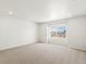 Finished basement with large window and neutral carpeting at 8888 Salida St, Commerce City, CO 80022