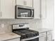 Close-up of a kitchen's gas cooktop and microwave at 8888 Salida St, Commerce City, CO 80022