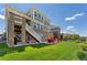 Expansive backyard featuring lush green lawn, a patio area, and a staircase leading to the upper level of the house at 23883 E Minnow Cir, Aurora, CO 80016