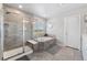 Modern bathroom with a glass-enclosed shower, soaking tub, and a large window for ample natural light at 23883 E Minnow Cir, Aurora, CO 80016
